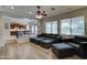 Open-concept living room with hardwood floors and ample natural light, with partial view into the kitchen at 14674 W Windsor Ave, Goodyear, AZ 85395