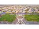 Aerial view of a community park featuring grassy fields, a playground, and walking paths amidst a residential neighborhood at 15652 N 175Th Ct, Surprise, AZ 85388