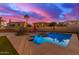 Twilight view of the pool featuring an attached spa and colorful outdoor umbrellas at 15652 N 175Th Ct, Surprise, AZ 85388