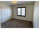 Bedroom with wood-look accent wall, neutral carpet and plantation shutters at 1637 W Green Tree Dr, San Tan Valley, AZ 85144