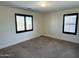 Bright bedroom featuring neutral walls, plush carpeting, and two windows with modern shutters at 1637 W Green Tree Dr, San Tan Valley, AZ 85144