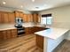 Modern kitchen with stainless steel appliances, wooden cabinets, and sleek countertops at 1637 W Green Tree Dr, San Tan Valley, AZ 85144