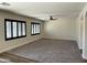 Bright living room with black window shutters, neutral walls, and ceiling fan at 1637 W Green Tree Dr, San Tan Valley, AZ 85144