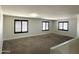 Open loft space featuring neutral carpet and multiple windows with black shutters at 1637 W Green Tree Dr, San Tan Valley, AZ 85144