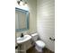 Charming powder room with pedestal sink and shiplap accent wall at 1637 W Green Tree Dr, San Tan Valley, AZ 85144