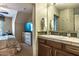 Bright bathroom showcasing a vanity, a glass block wall, and a doorway leading to the adjacent bedroom at 1664 E Bridgeport Pkwy, Gilbert, AZ 85295