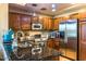 Kitchen with dark wood cabinets, stainless steel appliances, granite countertops, and a decorative backsplash at 1664 E Bridgeport Pkwy, Gilbert, AZ 85295