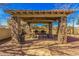 Outdoor picnic area featuring a covered pavilion with stone pillars, picnic tables, and a grill, perfect for gatherings at 1664 E Bridgeport Pkwy, Gilbert, AZ 85295