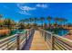 Community pond featuring a wood plank bridge and palm trees under bright blue sunny skies at 1664 E Bridgeport Pkwy, Gilbert, AZ 85295