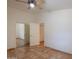 Bedroom with tile flooring, a ceiling fan, a closet, and a door that leads to another room at 1762 N Terrace Cir, Casa Grande, AZ 85122