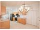 View of kitchen with stainless steel refrigerator and dining area with chandelier at 1762 N Terrace Cir, Casa Grande, AZ 85122