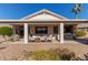 Comfortable covered back patio area with multiple seating arrangements and an outdoor grill at 17697 W Sunbelt Dr, Surprise, AZ 85374