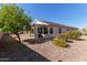 View of the back patio with a grill and desert landscaping including trees and bushes at 17697 W Sunbelt Dr, Surprise, AZ 85374