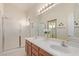 Bright bathroom featuring double sinks, a large mirror, and a glass-enclosed shower at 17697 W Sunbelt Dr, Surprise, AZ 85374