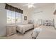 Cozy bedroom with twin beds, a large window, and a neutral color palette at 17697 W Sunbelt Dr, Surprise, AZ 85374