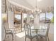 Elegant dining area with glass table, chandelier, and sliding door to the patio at 17697 W Sunbelt Dr, Surprise, AZ 85374