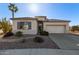 Charming single-story home with desert landscaping, lush greenery, and a two-car garage at 17697 W Sunbelt Dr, Surprise, AZ 85374