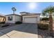 Single story home featuring a desert landscape with a two car garage and a large driveway at 17697 W Sunbelt Dr, Surprise, AZ 85374