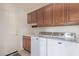 Well-equipped laundry room with cabinets, a utility sink, and modern washer and dryer at 17697 W Sunbelt Dr, Surprise, AZ 85374