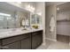 Double sink bathroom vanity with a view of the walk-in closet and glass enclosed shower at 1780 W Sombra Ave, Apache Junction, AZ 85120