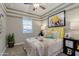 Bedroom featuring a window for natural light, ceiling fan, colorful pillows, and playful decor at 1780 W Sombra Ave, Apache Junction, AZ 85120