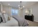 Bright bedroom with a modern light fixture, window, plush pillows, and neutral color scheme at 1780 W Sombra Ave, Apache Junction, AZ 85120