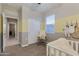 Neutral Bedroom features a white crib, rocker, and closet, with soft yellow and gray accents at 1780 W Sombra Ave, Apache Junction, AZ 85120