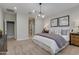 Serene main bedroom with neutral tones, modern light fixture, and ensuite bathroom access at 1780 W Sombra Ave, Apache Junction, AZ 85120