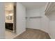 Empty walk-in closet with carpet flooring, white walls, and shelving plus a glimpse into the bathroom at 1780 W Sombra Ave, Apache Junction, AZ 85120