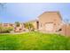 Expansive backyard with lush green grass, a sparkling pool, and desert landscaping surrounding the property at 19727 E Julius Rd, Queen Creek, AZ 85142