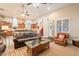 Inviting living room featuring a plush leather sofa, glass top coffee table, and seamless transition to the kitchen at 19727 E Julius Rd, Queen Creek, AZ 85142