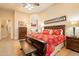 Spacious main bedroom featuring a king bed, bench, and en-suite bathroom entrance at 19727 E Julius Rd, Queen Creek, AZ 85142