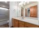 Bathroom featuring a bathtub-shower combo and rustic wood cabinets at 19927 W Meadowbrook Ave, Litchfield Park, AZ 85340