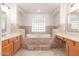 Well-lit bathroom featuring dual vanities and a luxurious soaking tub at 19927 W Meadowbrook Ave, Litchfield Park, AZ 85340