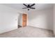 Bedroom with neutral carpet features a ceiling fan and a rustic wood door at 19927 W Meadowbrook Ave, Litchfield Park, AZ 85340