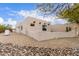 Rear exterior with stucco walls, a rock landscape, desert plants and an architectural style providing privacy and charm at 19927 W Meadowbrook Ave, Litchfield Park, AZ 85340