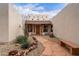 Inviting entryway with a tiled roof, stucco walls, desert plants, and a stone path, creating an inviting atmosphere at 19927 W Meadowbrook Ave, Litchfield Park, AZ 85340