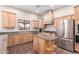 Beautiful kitchen featuring stainless steel appliances, granite countertops, custom cabinetry, and tile floors at 19927 W Meadowbrook Ave, Litchfield Park, AZ 85340