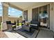 Covered back patio featuring cushioned seating, plants, and views of the backyard at 20477 N 91St Dr, Peoria, AZ 85382