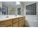 Spacious bathroom boasting double sinks and a sleek glass block window over the tub at 20477 N 91St Dr, Peoria, AZ 85382