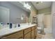 Bathroom featuring double sinks, vanity, a shower and a commode at 20477 N 91St Dr, Peoria, AZ 85382