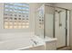 Bathroom with soaking tub and glass shower, plus a glass block window for natural light at 20477 N 91St Dr, Peoria, AZ 85382