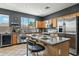 Well-lit kitchen featuring an island with seating, stainless steel appliances, and modern tile backsplash at 20477 N 91St Dr, Peoria, AZ 85382