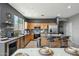 Open kitchen with stainless steel appliances, kitchen island, and adjacent dining area with a glass table at 20477 N 91St Dr, Peoria, AZ 85382