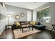 Bright living room featuring a dark leather sofa, decorative pillows and area rug at 20477 N 91St Dr, Peoria, AZ 85382