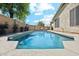 A private pool is surrounded by lush greenery, a brick wall, and a covered patio with lounge chairs at 20477 N 91St Dr, Peoria, AZ 85382