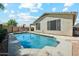 A private pool surrounded by lush green trees and a brick wall with seating space to relax at 20477 N 91St Dr, Peoria, AZ 85382