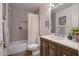 Well-lit bathroom featuring a shower-over-tub with gray tiling and a vanity with a white countertop and gray wood cabinetry at 2142 E Turney Ave # 4, Phoenix, AZ 85016