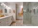 Bathroom featuring dual sinks with white vanities, quartz countertops, modern lighting, and updated shower at 2142 E Turney Ave # 4, Phoenix, AZ 85016