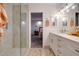 Bathroom featuring dual sinks with white vanities, quartz countertops, modern lighting, and updated shower at 2142 E Turney Ave # 4, Phoenix, AZ 85016